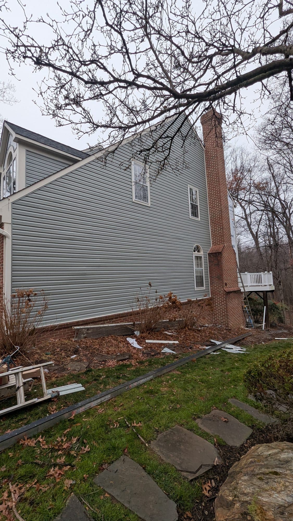 New siding installed on the lower portion of a home's exterior above the brick foundation
